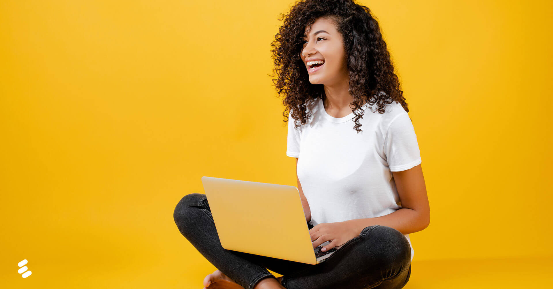 A young woman using a laptop on the floor.